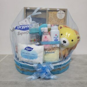 Blue baby hamper from Gin Thye featuring Muji baby gift set, Johnson & Johnson products, and baby essentials in a yellow oval basket